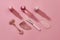 Flat lay of rose quartz facial massage tools such as gua sha stone scrapers, face roller and beauty products in plastic