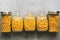 Flat lay in a row of varied pasta in jars on a gray background. Top view, copy space