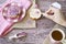 Flat lay with rusk, sweet pink purple sprinkles and cup of tea. Against wooden background