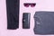 Flat lay set of casual men fashion clothes and accessories. Everyday look: grey shirt, black jeans, wallet and sunglasses on pink