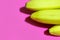 Flat lay of several yellow bananas on a pink background top view. Copy space for text