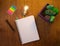 Flat lay shot of a copybook, a pen, a lamp and colorful stickers on a wooden table