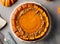Flat lay shot of a pumpkin pie over gray table. AI generated