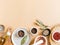 Flat lay of small bowls various dry spices, wood kitchen utensils, olive oil in glass bottle on beige background. Top view. copy