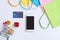 Flat lay of smartphone, credit card, miniature gift boxes. trolley and colorful bags on white table. Top view and copy space for