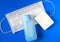 Flat lay of Soap, medical surgical mask and hand sanitizer on blue background