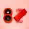 Flat lay of sports equipment. Fitness rubber bands and dumbbells on pink background, top view