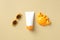 Flat lay sunscreen tube, baby glasses, sand mold on sand color background. Kids sun protection concept