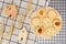 Flat lay of sweets, Danish butter cookie on rattan plate and model house on rack with gingham cloth