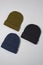 Flat lay template of khaki, dark blue and black hats, hipster beanie set isolated over gray background