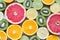 Flat lay top view of colorful variety of fresh citrus fruits half cut background