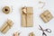 Flat lay top view gift wrapping composition. homemade wrapped  present boxes, decoration and tools on white background for