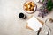 Flat lay, top view lifestyle still life composition with coffee cup, blank paper card, kraft envelope, cookies, ribbon, lilac