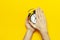 Flat lay top view male hand holding black vintage alarm clock on bright yellow color background with copy space. Creative Time