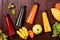 Flat lay top view orange, yellow, green, red juice bottles with banana, guava, spinach and mango on wooden table. Healthy lifestyl