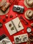 Flat Lay of Travel Essentials on a Vibrant Red Background with Notebook, Camera, Straw Hat, Clock, Glasses, and Leather