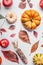 Flat lay of various colorful pumpkin, apples and fall leaves on white table background, top view. Autumn composing or pattern bac