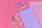 Flat lay with various sewing tools like fabric, scissors, spools, buttons or pins on pink background with  copy space