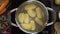 Flat lay video: the cook throws peeled potatoes to the boiling water, tabletop of boiling vegetables, cooking the soup