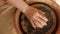 Flat lay view from above of female hands sticking raw clay to pottery wheel