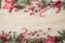 Flat lay view of Christmas frame background. Branches with red berries  felt star ornaments  red candy canes and spruce branches.