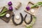 Flat lay view of two rusty small and big horseshoes on light wooden board background, decorated with white small candles.