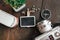 flat lay view wooden signage,vintage camera, compass and artificial plant on wooden background