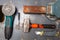 Flat lay view of a workbench with a set of tools consisting of a large heavy vise, angle grinder, screwdriver, cutter,