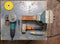 Flat lay view of a workbench with a set of tools consisting of a large heavy vise, angle grinder, screwdriver, cutter,