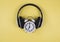 Flat lay of vintage alarm clock show 7 o`clock cover with headphones on yellow background ,time to listen to music concept or