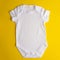 Flat Lay a white bodysuit for a child on a yellow background. Layout for design and placement of logos, advertising