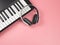 Flat lay of white headphones on electric piano on pink background with copy space.musician work set