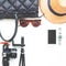 Flat lay of woman accessories with cellphone film camera and black color items on white background