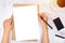 Flat lay of woman hand writing in a blank white paper on brown paper envelope with pencil ,mobile phone , credit card