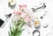 Flat lay women`s accessories set - tulips bouquet, cosmetics, glasses, phone, apple, headphones on light background top view. Bea