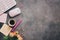 Flat lay women workspace - modern keyboard, mouse, cup of coffee, rose flowers, jewelry and stationery on a dark rustic background