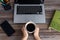 Flat lay workspace desk top view: laptop keyboard, phone, notebook and cup of coffee in hands. Coffee break!