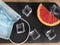Flat llay of coronavirus icons as facial mask , fresh fruit slice  , ices cubes and others on black  background representing