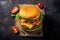 Flat-lying on table beef burger with pods of hot pepper on dark background
