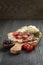 Flat pita bread with salami and vegetables on wood