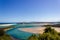 Flat sand dunes at delta of Nambucca river entering Pacific ocean through wide sandy beach of Australian coast around Nambucca