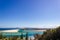 Flat sand dunes at delta of Nambucca river entering Pacific ocean through wide sandy beach of Australian coast around Nambucca