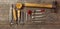 Flat set of leather tool kit for beginners. Old retro instrument for leather working on wood background. Panoramic.