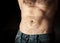 Flat sporty male belly on dark background