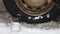 A flat tire of a car is quickly inflated by a compressor on white snow