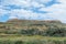 Flat topped plateau hill in the rural village of Ghasri, Gozo, Malta, with the Ta Giordan lighthou