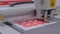 Flatbed cutter, plotter cutting red label stickers at exhibition - close up