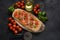 Flatbread pizza garnished with fresh cherry tomatoes, basil, cheese and olive oil on wooden pizza board.