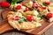 Flatbread pizza with mozzarella, tomatoes, spinach and artichokes, close up