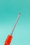 Flathead Screwdriver Over a Turquoise Background